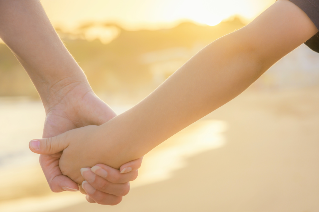 Les mains d'une maman et de son fils qui se tiennent qui dégage leur complicité ,leur soutien et leur amour.