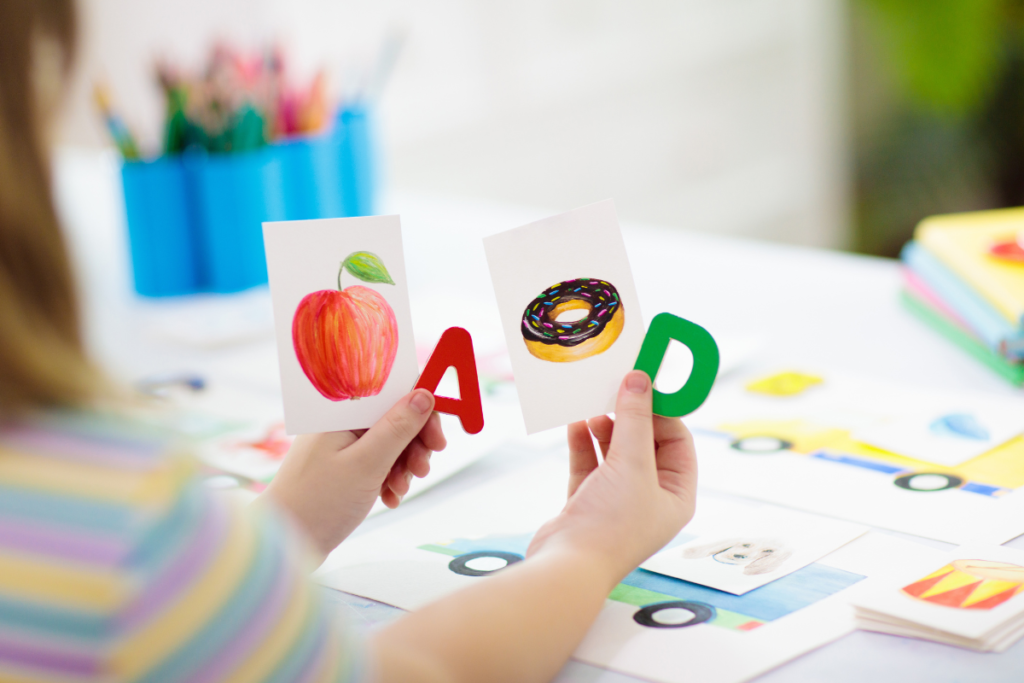 Des cartes flash représentant une pomme, un donuts accompagnés de la lettre A et D afin que l'enfant réunisse la première lettre de chaque image.